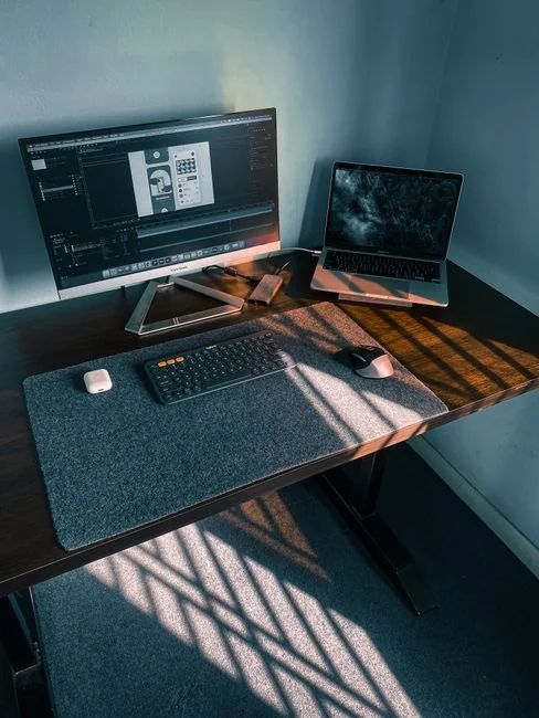 Stylish and efficient workspace with multiple monitors, laptop, and smartphone, showcasing a web design project.