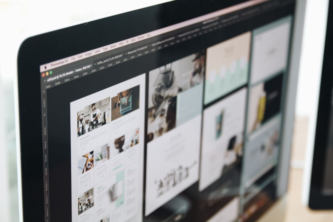 Un moderno schermo di computer che mostra un lavoro di web design, con immagini creative in un ambiente di lavoro.
